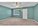 A bright bedroom with teal walls, neutral carpet, a ceiling fan, and a sunny window at 121 Drumbuie Pl, Garner, NC 27529