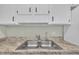 Kitchen showcasing stainless steel sink, white cabinetry, and granite countertops at 121 Drumbuie Pl, Garner, NC 27529