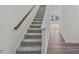 Carpeted staircase with wooden handrail leading to the upper level at 130 N Keatts Winner Ct, Wilson's Mills, NC 27520