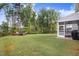 Expansive backyard with lush green grass, mature trees, and a fire pit area at 130 Stromness Path, Clayton, NC 27527
