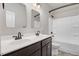 A bathroom featuring double sinks and a shower with tub in neutral tones and bronze fixtures at 130 Stromness Path, Clayton, NC 27527