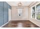 Bright bedroom featuring stylish blue accent wall, hardwood floors, and natural light from large windows at 130 Stromness Path, Clayton, NC 27527