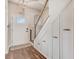 Bright entryway with hardwood floors, storage cabinets, staircase with white railing, and a modern light fixture at 130 Stromness Path, Clayton, NC 27527