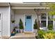 Welcoming front porch with a blue door, decorative plants, and cozy seating area at 130 Stromness Path, Clayton, NC 27527