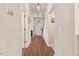 A long hallway with hardwood floors leads to the home's entryway with decorative wall art at 130 Stromness Path, Clayton, NC 27527