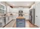 Bright kitchen featuring white cabinetry, stainless steel appliances, and a blue island perfect for culinary enthusiasts at 130 Stromness Path, Clayton, NC 27527