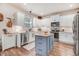 Modern kitchen with white cabinets, stainless steel appliances, and a blue island, ideal for cooking and entertaining at 130 Stromness Path, Clayton, NC 27527