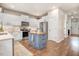 Modern kitchen with white cabinets, stainless steel appliances, and a blue island for a stylish cooking space at 130 Stromness Path, Clayton, NC 27527