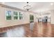 Open-concept living space showcasing hardwood floors, a modern chandelier, and a seamless connection to the kitchen at 130 Stromness Path, Clayton, NC 27527