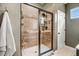 Modern walk-in shower featuring sleek black hardware and wood-look tile at 130 Stromness Path, Clayton, NC 27527