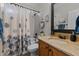 Well-lit bathroom featuring a tub, shower with curtain, and vanity with decorative mirror at 1320 Heritage Hills Way, Wake Forest, NC 27587