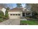 Charming home exterior features a manicured lawn, stone accents, a two car garage, and a cozy front porch at 1320 Heritage Hills Way, Wake Forest, NC 27587