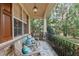 Inviting covered front porch featuring comfortable seating, stone accents, and outdoor lighting at 1320 Heritage Hills Way, Wake Forest, NC 27587