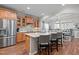 Open kitchen with a central island, stainless steel refrigerator, and seamless flow into dining area at 1320 Heritage Hills Way, Wake Forest, NC 27587