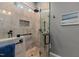 Modern walk-in shower featuring stone floors and walls, a glass door, and sleek hardware at 1320 Heritage Hills Way, Wake Forest, NC 27587