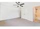 Well-lit bedroom with neutral carpet, a ceiling fan, and an en-suite bathroom with a shower and tub combination at 135 Cedar Elm Rd, Durham, NC 27713