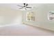 Spacious bedroom with soft carpet, a ceiling fan, and ample natural light from a decorative round window at 135 Cedar Elm Rd, Durham, NC 27713