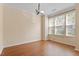 Bright living room featuring hardwood floors, a modern light fixture, and multiple windows for ample natural light at 135 Cedar Elm Rd, Durham, NC 27713