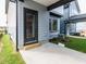 Backyard exterior featuring a concrete patio, grassy area, and the home's gray siding and black framed door at 14 Relaxing Way, Pittsboro, NC 27312