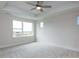 Spacious primary bedroom with tray ceiling, a ceiling fan, and multiple windows for natural light at 14 Relaxing Way, Pittsboro, NC 27312