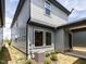 Exterior side view of a two-story home featuring gray siding, white-framed windows, and landscaping at 14 Relaxing Way, Pittsboro, NC 27312