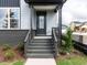 Inviting front porch with gray brick steps, sleek railings, and a modern black front door at 14 Relaxing Way, Pittsboro, NC 27312