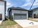 A gray two-car garage with modern design, showcasing ample parking space and adjacent landscaping at 14 Relaxing Way, Pittsboro, NC 27312