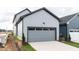 Attached two-car garage with a gray door and light gray siding, showcasing modern home design at 14 Relaxing Way, Pittsboro, NC 27312