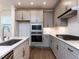 Stylish kitchen featuring stainless steel appliances, gray cabinets, and quartz countertops at 14 Relaxing Way, Pittsboro, NC 27312