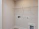 Bright laundry room featuring washer and dryer hookups and storage shelves at 14 Relaxing Way, Pittsboro, NC 27312