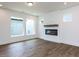 Bright and open living room with modern fireplace, hardwood flooring, and large windows at 14 Relaxing Way, Pittsboro, NC 27312