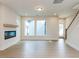 Spacious living room with hardwood floors, a fireplace, large windows, and a staircase at 14 Relaxing Way, Pittsboro, NC 27312