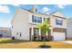 Charming two-story home featuring a brick facade, attached garage, and manicured front yard with a young tree at 1427 Carisbrooke Dr, Mebane, NC 27302