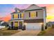 Beautiful two-story home with brick and vinyl siding and an attached two-car garage, and front porch at 1427 Carisbrooke Dr, Mebane, NC 27302