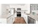 Kitchen view showcasing white cabinets, granite counters, stainless steel appliances, and wood flooring at 1427 Carisbrooke Dr, Mebane, NC 27302