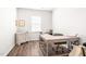 Well-lit office with wood flooring, featuring an L-shaped desk, white walls, and natural light from a window at 1427 Carisbrooke Dr, Mebane, NC 27302