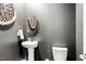 Stylish powder room featuring pedestal sink, decorative mirror, and gray walls at 1427 Carisbrooke Dr, Mebane, NC 27302