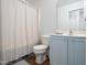 Clean bathroom with a shower curtain, toilet, and light blue cabinets at 14315 Foxcroft Rd, Raleigh, NC 27614