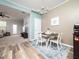 Cozy dining room featuring a modern chandelier, white chairs, accent wall paint, and wood flooring at 14315 Foxcroft Rd, Raleigh, NC 27614
