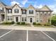 Street view of well maintained townhomes with colorful siding, manicured shrubs, and clearly marked parking spaces at 14315 Foxcroft Rd, Raleigh, NC 27614