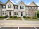 Charming townhome exterior featuring varied siding and stone accents, with a well-manicured lawn and dark shutters at 14315 Foxcroft Rd, Raleigh, NC 27614