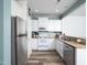 Bright kitchen with white cabinets, stainless steel appliances, granite counters, and wood-look flooring at 14315 Foxcroft Rd, Raleigh, NC 27614