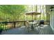 Spacious wooden deck set up for outdoor dining with seating for four, an umbrella, and a grill at 1505 Sharnbrook Ct, Raleigh, NC 27614