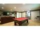 Finished basement with a pool table, wet bar, storage closets, and a comfortable leather sofa at 1505 Sharnbrook Ct, Raleigh, NC 27614