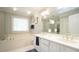 Bright bathroom featuring a double vanity, bathtub, and natural light, providing a serene and functional space at 1505 Sharnbrook Ct, Raleigh, NC 27614