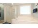 Bathroom featuring a shower, tub, and natural light, for a soothing and functional space at 1505 Sharnbrook Ct, Raleigh, NC 27614