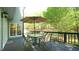 Outdoor deck features seating area with an umbrella and wood decking overlooking the backyard at 1505 Sharnbrook Ct, Raleigh, NC 27614