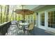 Outdoor deck with a dining table, seating, and a view of the surrounding trees at 1505 Sharnbrook Ct, Raleigh, NC 27614