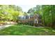 Stately brick home with a manicured lawn and mature trees providing shade and curb appeal at 1505 Sharnbrook Ct, Raleigh, NC 27614