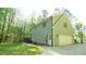 Exterior view showing a house with attached garage, a deck, and a well-maintained lawn in wooded surrounding at 1505 Sharnbrook Ct, Raleigh, NC 27614